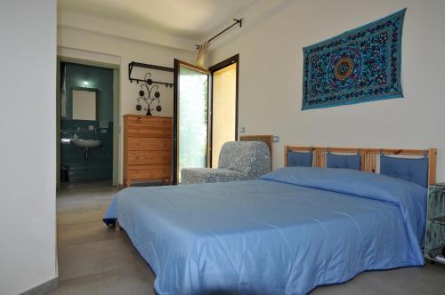 um quarto com uma cama azul e uma casa de banho em Casalotto Francescano em Mengara