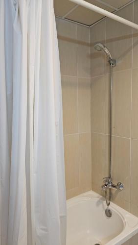 La salle de bains est pourvue d'une douche avec un rideau de douche blanc. dans l'établissement Full Sea view studio, à Ras al Khaimah