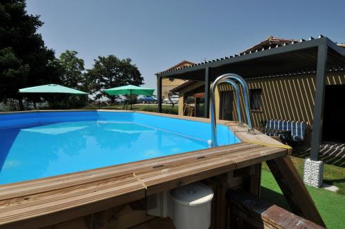 a large blue swimming pool with a wooden deck at Casalotto Francescano in Mengara