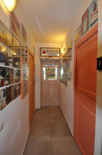 a hallway with a door and pictures on the walls at Casalotto Francescano in Mengara