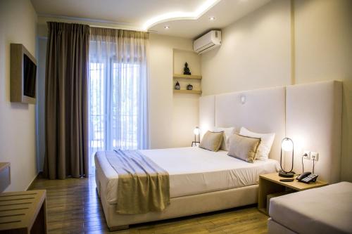 a hotel room with a large bed and a window at Kasta Beach Hotel in Ofrínion