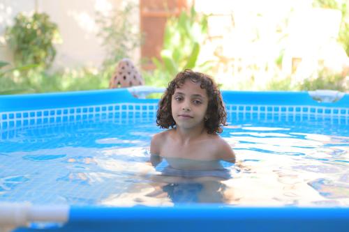 ルクソールにあるLuxor Villa Hatshepsutの小さな子供がスイミングプールで泳ぐ
