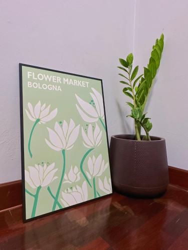a flower market sign and a potted plant on a table at Kong Khong Homestay in Hat Yai
