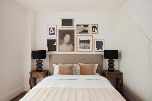 a bedroom with a bed with pictures on the wall at The Ravenscourt Park Escape - Bright 2BDR Flat in London