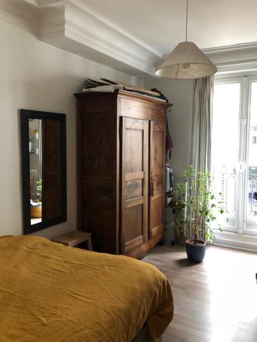 - une chambre avec un lit, une armoire et une plante dans l'établissement Nice and practical apartment to enjoy Paris close to Montmartre, à Paris