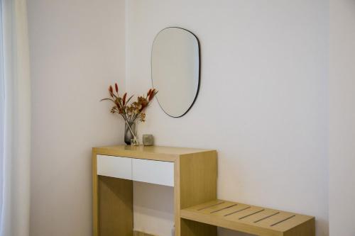 a dressing table with a mirror on a wall at Kasta Beach Hotel in Ofrínion