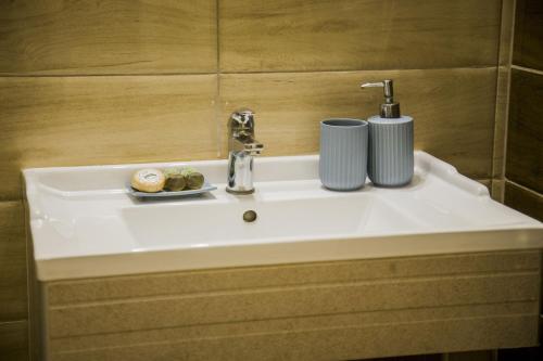 a bathroom sink with two cups on top of it at Kasta Beach Hotel in Ofrínion