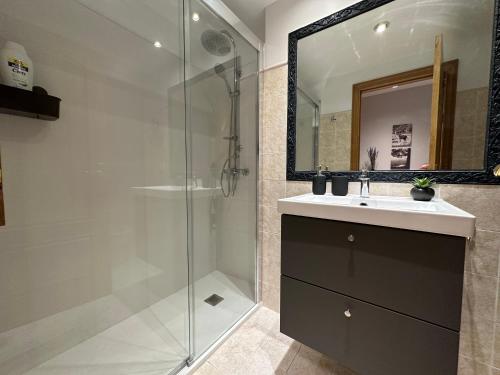 ein Bad mit einer Dusche, einem Waschbecken und einem Spiegel in der Unterkunft Oktheway Los Arces in A Coruña