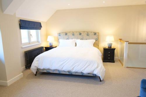 a bedroom with a large white bed with two lamps at Greentrees Estate - The Beech Cottage in Haywards Heath