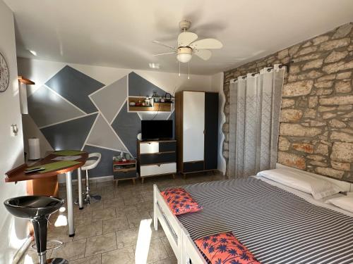 a bedroom with a bed and a stone wall at Apartment Julia in Nedeščina