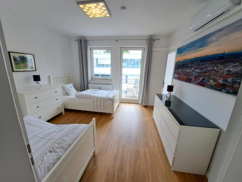 een slaapkamer met 2 bedden en een bank in een kamer bij East Park Apartments Baumkirchner Str 18 in München