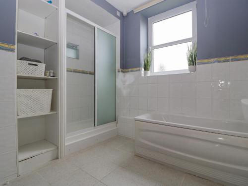 a bathroom with a tub and a sink and a window at The Annexe in Lydney