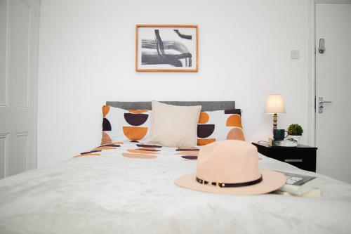 a hat sitting on top of a bed with pillows at Serene and Tranquil Escape in Liverpool