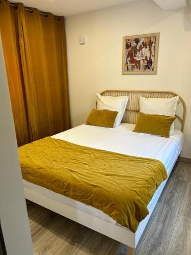 a bedroom with a large bed with a yellow blanket at Charmant appartement à Ajaccio in Ajaccio