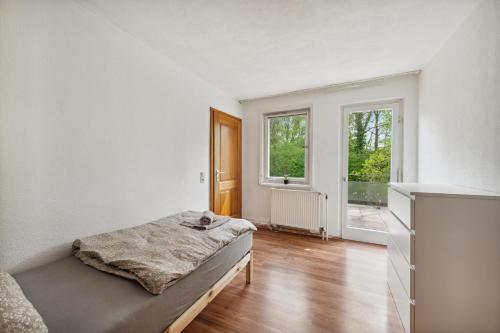 a white bedroom with a bed and a window at home2stay worker Apartments Nürtingen-Zizishausen Ap1 in Nürtingen