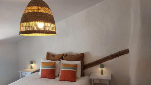 a bedroom with a bed with a chandelier above it at El Paraíso Perdido in Casabermeja