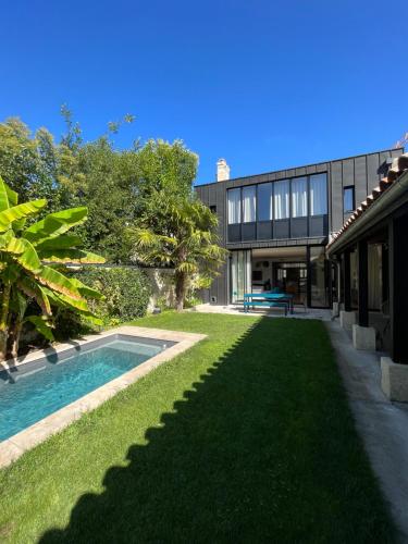 une cour arrière avec une piscine et un bâtiment dans l'établissement Maison familiale Chartrons 250m2 jardin + piscine, à Bordeaux