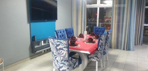 a dining room table with blue chairs and a red table cloth at 1403 on 10 South Beach in Durban