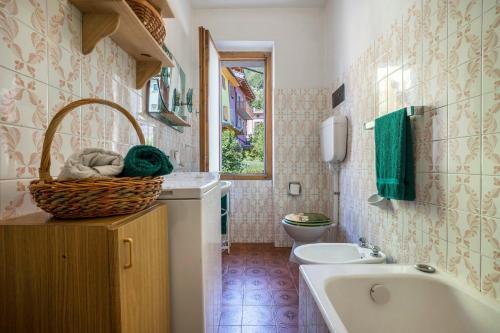 bagno con vasca, lavandino e servizi igienici di Casa nel Borgo Edera a Breguzzo