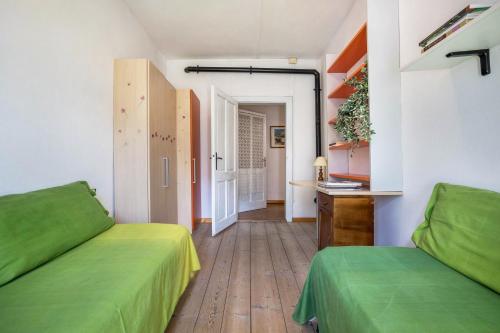 una camera con due letti verdi e un corridoio di Casa nel Borgo Edera a Breguzzo
