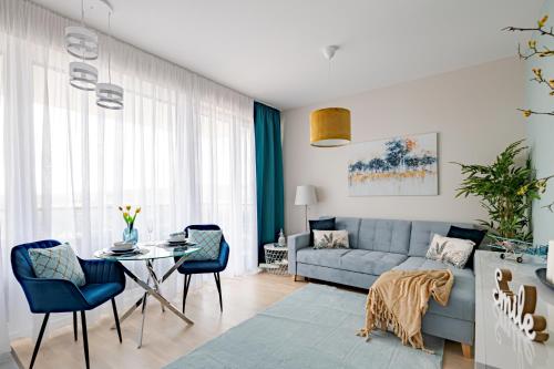 a living room with a blue couch and a table at Waterfront Luxury Residence - Paid Parking Option in Budapest