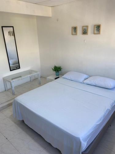 1 cama blanca grande en una habitación con espejo en Habitaciones independientes cerca al aeropuerto 3, en Cartagena de Indias
