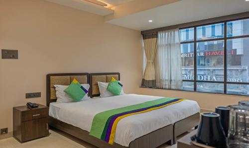 a bedroom with a large bed and a window at Treebo Su Casa Grand in Visakhapatnam