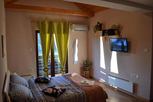 een slaapkamer met een bed en een raam met gele gordijnen bij Madora - Studio Apartman in Fužine