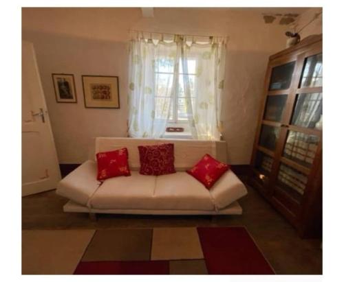 a living room with a white couch with red pillows at Villa del Borgo in San Benedetto Val di Sambro
