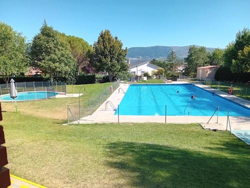 a large swimming pool in a yard at Casita con encanto tranquilidad VILLAVIEJA DEL LOZOYA Wi-Fi EN SIERRA DE MADRID Y A 50 MINUTOS DE CAPITAL in Villavieja del Lozoya