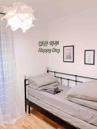 1 dormitorio con 1 cama y un cartel de día feliz en la pared en Central Apartment in Frankfurt a.M. en Frankfurt