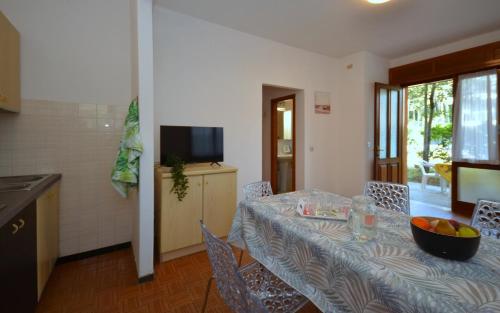 una sala da pranzo con tavolo e cesto di frutta di Villa Rosanna a Lignano Sabbiadoro
