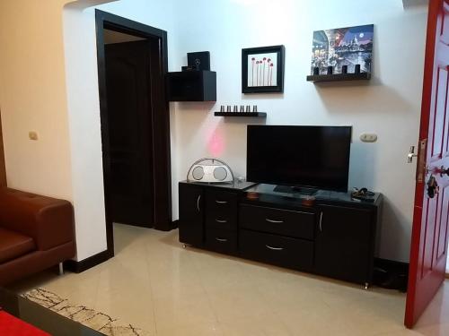 a living room with a flat screen tv on a dresser at شرم ستار مكتب رقم 230 in Sharm El Sheikh