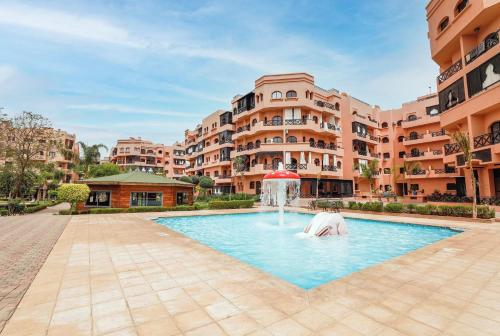 uma piscina com uma fonte no meio de um edifício em Appartement Premium Village, 5 piscines em Marrakech