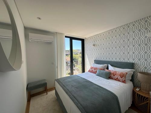 een slaapkamer met een groot bed en een raam bij BONFIM LIVING - Great location, al fresco dining and free private parking in Porto