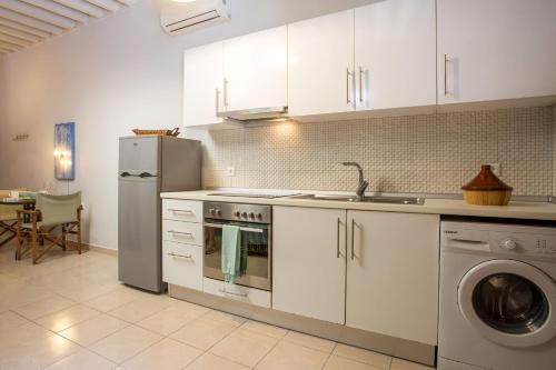 uma cozinha com armários brancos, um frigorífico e uma máquina de lavar louça em Art house old town in Ilha de Rhodes