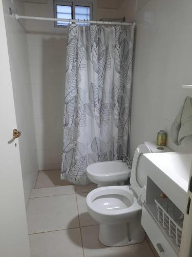 a bathroom with a toilet and a shower curtain at Finca La Chiqueta in Albardón