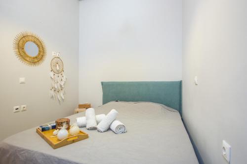 uma cama com uma bandeja de toalhas e um espelho em Art house old town in Ilha de Rhodes