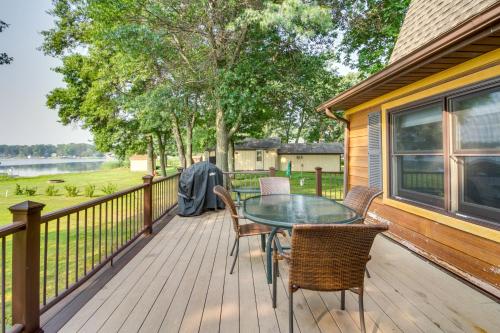 a patio with a table and chairs on a deck at Large Home on Lake Edward with Deck and Fire Pit! in Nisswa