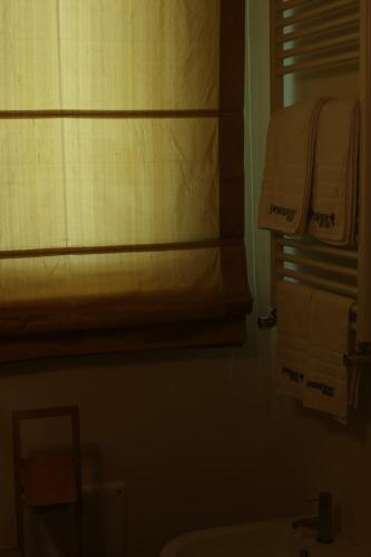 a bathroom with a sink and towels on a shelf at Tenuta Pezzapane in Alvignanello
