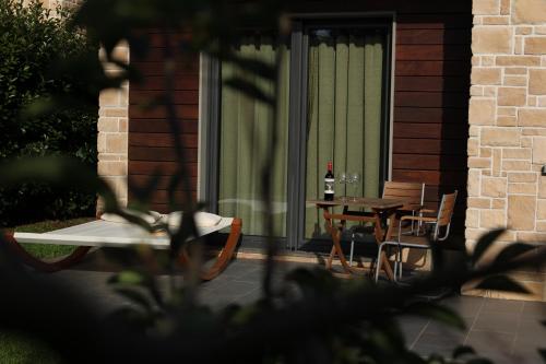 a patio with a table and chairs and a bottle of wine at Tenuta Pezzapane in Alvignanello