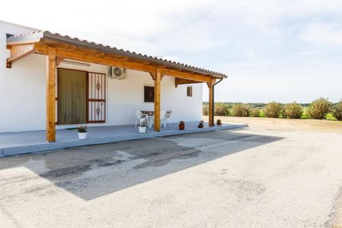 Casa blanca pequeña con techo de madera en Villa Mara en Specchiolla 