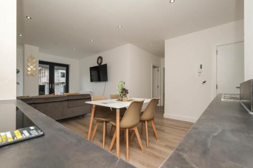 a kitchen and living room with a table and chairs at Brand New 2 bedroom apartment Centre of Solihull in Solihull