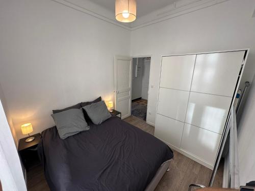 a bedroom with a large bed and two lamps at Typique 3 fenêtres marseillais in Marseille