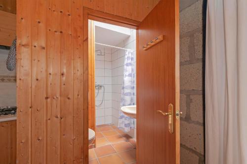 a bathroom with a wooden door and a sink at Casa Killa in Granadilla de Abona