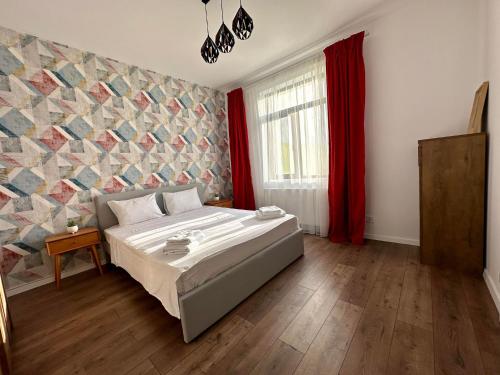 um quarto com uma cama e uma cortina vermelha em XOX Villa House & Garden Bucharest em Bucareste