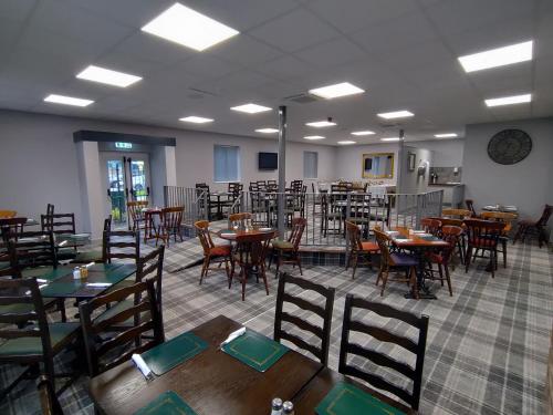 uma sala de jantar vazia com mesas e cadeiras em Harleys Inn em Chesterfield