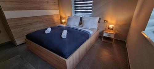 a bedroom with a large bed with blue sheets and white pillows at Hős-Ceglédi Vendégház Miskolc -Önálló otthon, mely csak az Önöké in Miskolc