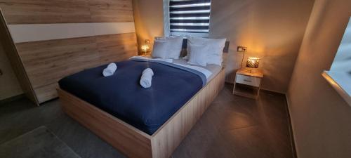 1 dormitorio con 1 cama grande con sábanas azules y almohadas blancas en Hős-Ceglédi Vendégház Miskolc -Önálló otthon, mely csak az Önöké, en Miskolc