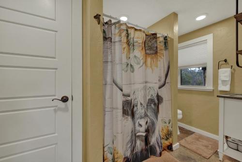 uma cortina de chuveiro com uma vaca na casa de banho em Ohana Ranch Cabin - 12 minutes to Historic Main St em Fredericksburg